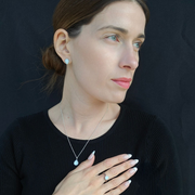 Femme portant l’ensemble Excellence Goutte en argent : bague, boucles d’oreilles et collier au lait maternel
